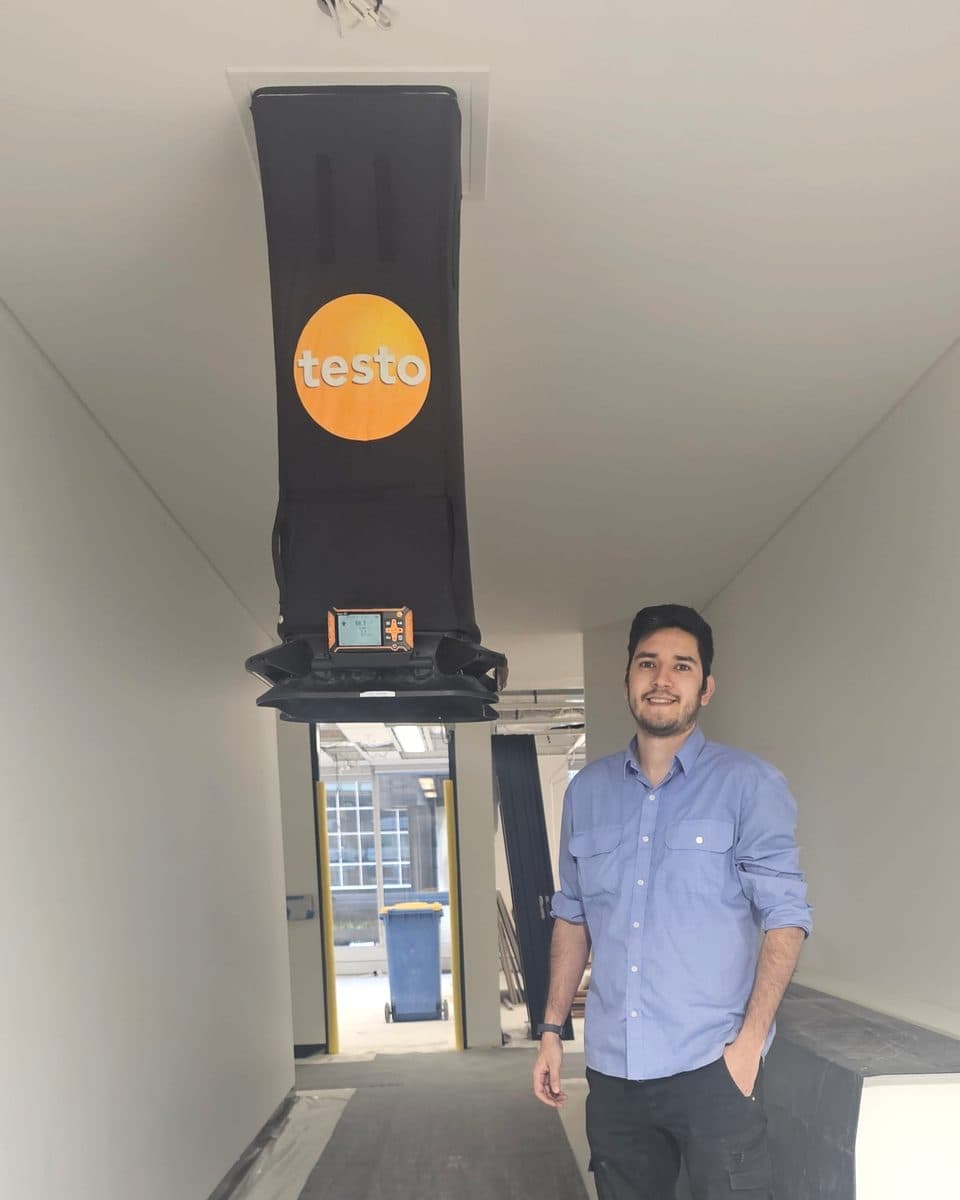 ENGIC founder Ivan Camacho standing under a capture hood held to the ceiling by ENGIC's own fitting
