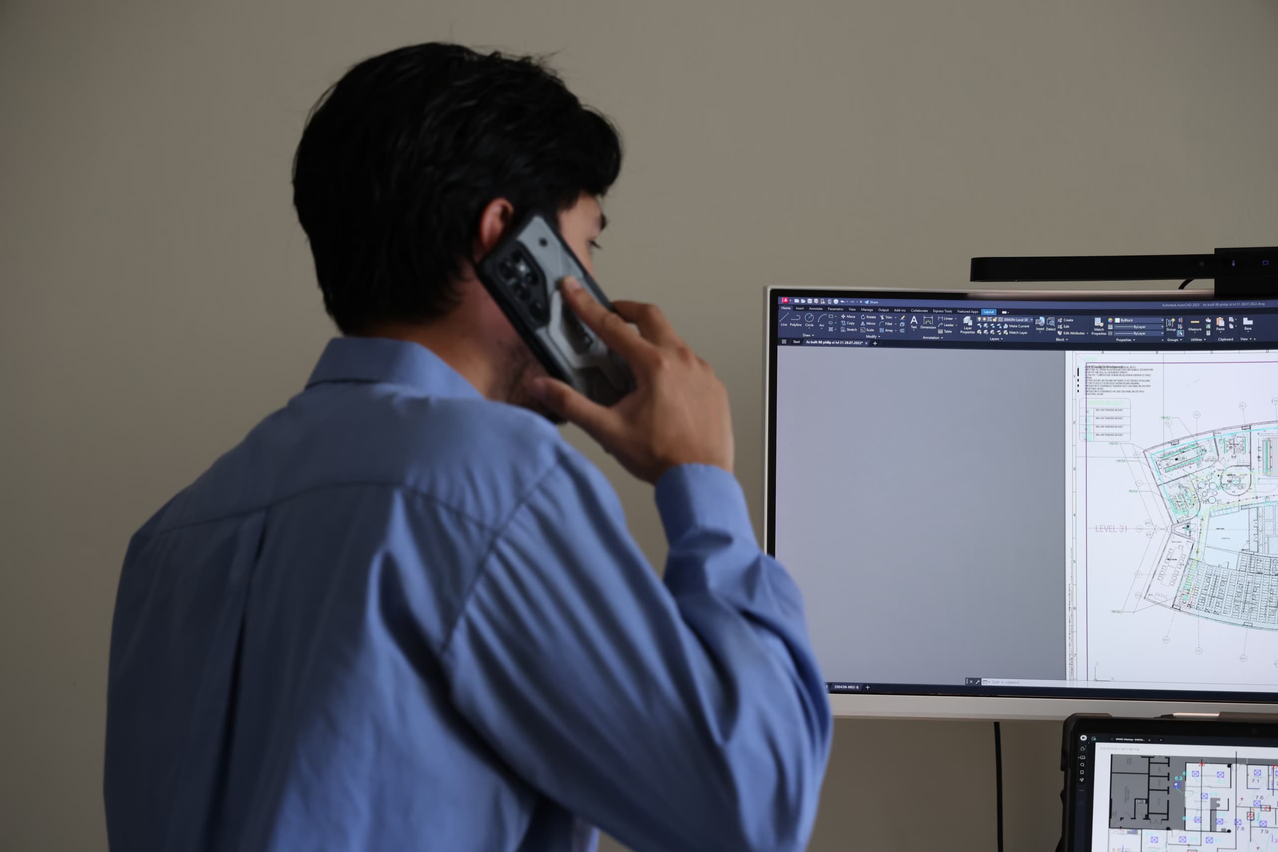 ENGIC technician on a phone call reviewing HVAC drawings on screen